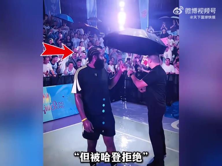 工作人员想为哈登撑伞,但登哥拒绝,选择了和球迷们一起淋雨